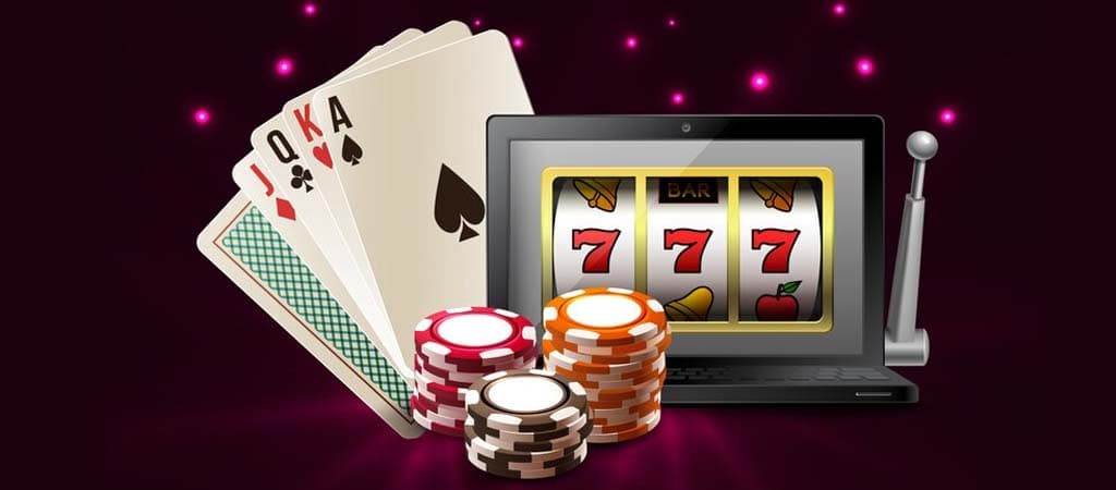Online kaszinó nyerőgép laptopon, pókerkártyák, 777 szimbólum és kaszinó zsetonok.