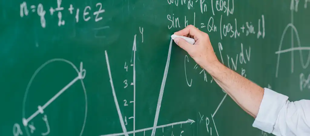 Matematika képletek és grafikonok egy zöld táblán, egy kéz krétával rajzol.