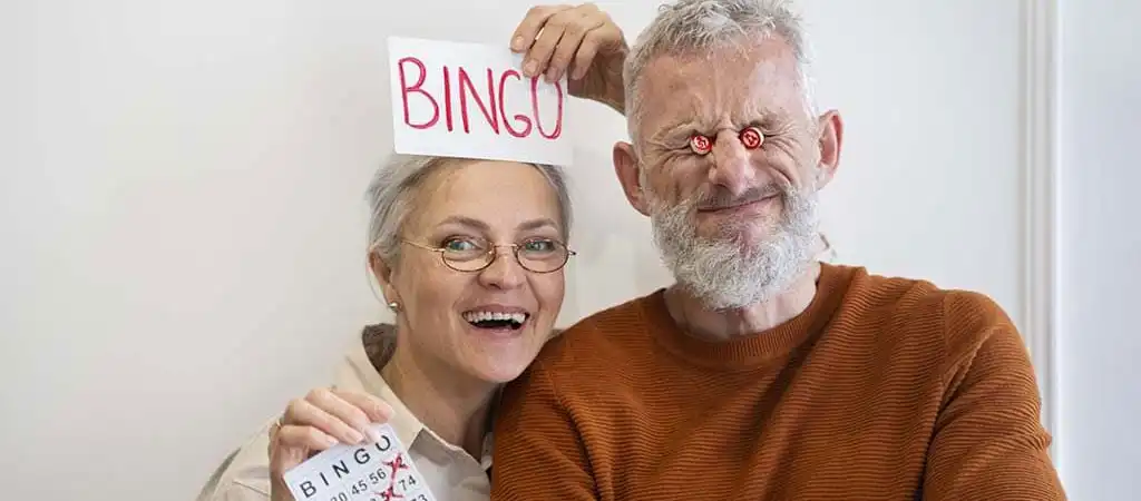 Mosolygó idősebb pár bingó szelvénnyel és BINGO felirattal.